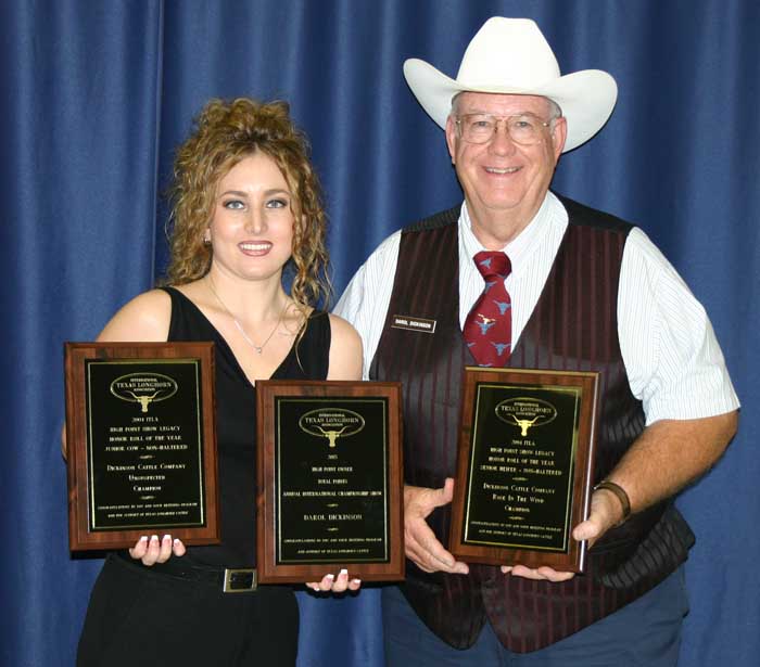 Darol Dickinson wearing cowboy hat presented with awards by unknown woman