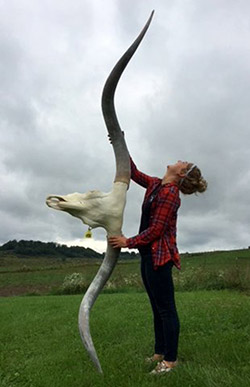 Rose holding up Texas Longhorn Steer Sequoia Man's skull. Come for a tour, visit our store and see great skulls like this.